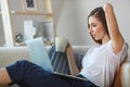 Young woman sitting with laptop on sofa at her home Royalty Free Stock Photo