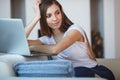 Young woman sitting with laptop on sofa at her home Royalty Free Stock Photo