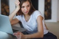 Young woman sitting with laptop on sofa at her home Royalty Free Stock Photo