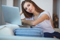 Young woman sitting with laptop on sofa at her home Royalty Free Stock Photo