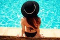 Young woman sitting on the ledge of the pool Royalty Free Stock Photo