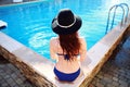 Young woman sitting on the ledge of the pool Royalty Free Stock Photo