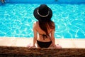 Young woman sitting on the ledge of the pool Royalty Free Stock Photo