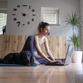 Young woman sitting on a living room floor using or working on laptop computer Royalty Free Stock Photo