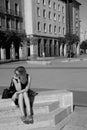 Young woman sitting on a marble bench holding her head withanhand Royalty Free Stock Photo