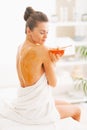 Young woman sitting on massage table with honey plate Royalty Free Stock Photo