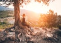 Young woman sitting on the mountain at sunset. Summer landscape Royalty Free Stock Photo