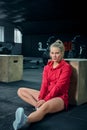 Young woman sitting near a box at gym after her workout and looking at the camera. Royalty Free Stock Photo