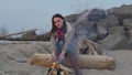 Young woman sitting near the fire in the evening. fire.