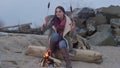 Young woman sitting near the fire in the evening. Fire.