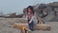 Young woman sitting near the fire in the evening. Fire.