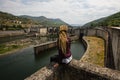 Young woman sitting near an old hydroelectric plant. Royalty Free Stock Photo