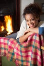 Young woman sitting by open fire