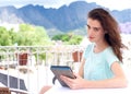 Young woman sitting at outdoor cafe with digital tablet Royalty Free Stock Photo