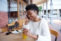 Young woman sitting at outdoor cafe talking on cell phone Royalty Free Stock Photo