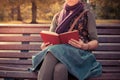 Young woman sitting on park bench with book Royalty Free Stock Photo