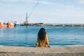 Young woman sitting on pier and looking away Royalty Free Stock Photo