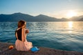 Young woman sitting on the pier at sunrise Royalty Free Stock Photo