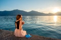 Young woman sitting on the pier at sunrise Royalty Free Stock Photo