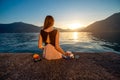 Young woman sitting on the pier at sunrise Royalty Free Stock Photo