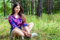 Young woman sitting in a pine tree forest Royalty Free Stock Photo