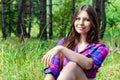 Young woman sitting in a pine tree forest Royalty Free Stock Photo