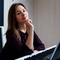 Young woman sitting and playing on the electronic piano Royalty Free Stock Photo