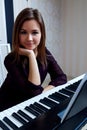 Young woman sitting and playing on the electronic piano Royalty Free Stock Photo