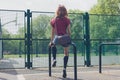 Young woman sitting on a rail in park Royalty Free Stock Photo