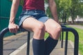 Young woman sitting on a rail in park Royalty Free Stock Photo