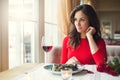 Young woman sitting in the restaurant dining looking out the window Royalty Free Stock Photo