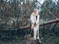 Young woman sitting and resting in forest on fallen trunk pine tree