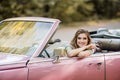 Young woman sitting in retro convertible