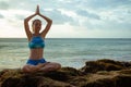 Young woman meditating, practicing yoga and pranayama with namaste mudra at the beach, Bali. Copy space Royalty Free Stock Photo