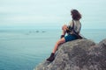 Young woman sitting on a rock by the sea Royalty Free Stock Photo