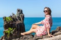 Young woman sitting on rocks near the sea. Royalty Free Stock Photo