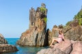 Young woman sitting on rocks sea coast. Royalty Free Stock Photo