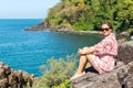 Young woman sitting on rocks sea coast. Travel. Royalty Free Stock Photo