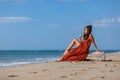 YOUNG WOMAN SITTING ON THE SAND OF THE BEACH Royalty Free Stock Photo