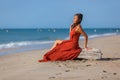 YOUNG WOMAN SITTING ON THE SAND OF THE BEACH Royalty Free Stock Photo