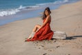 YOUNG WOMAN SITTING ON THE SAND OF THE BEACH Royalty Free Stock Photo