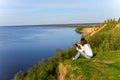 Young woman sitting on the shore of the lake with tablet compute Royalty Free Stock Photo