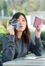 Young woman sitting showing passport and credit card Royalty Free Stock Photo