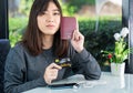 Young woman sitting showing passport and credit card Royalty Free Stock Photo