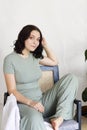 Young woman sitting sideways on wooden chair Royalty Free Stock Photo