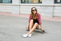 Young woman sitting on the skater. Smiling woman with skateboard in outdoors Royalty Free Stock Photo