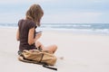 Young woman sitting with smart phone on a beach. Relaxation concept Royalty Free Stock Photo