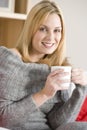 Young Woman Sitting On Sofa With Cup Of Coffee Royalty Free Stock Photo