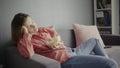 Young woman sitting on the sofa, eating popcorn, watching TV and falling alseep