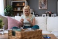 Young woman sitting on sofa at home holding pregnancy test, hope that test result is positive and that she si pregnant. Female is Royalty Free Stock Photo